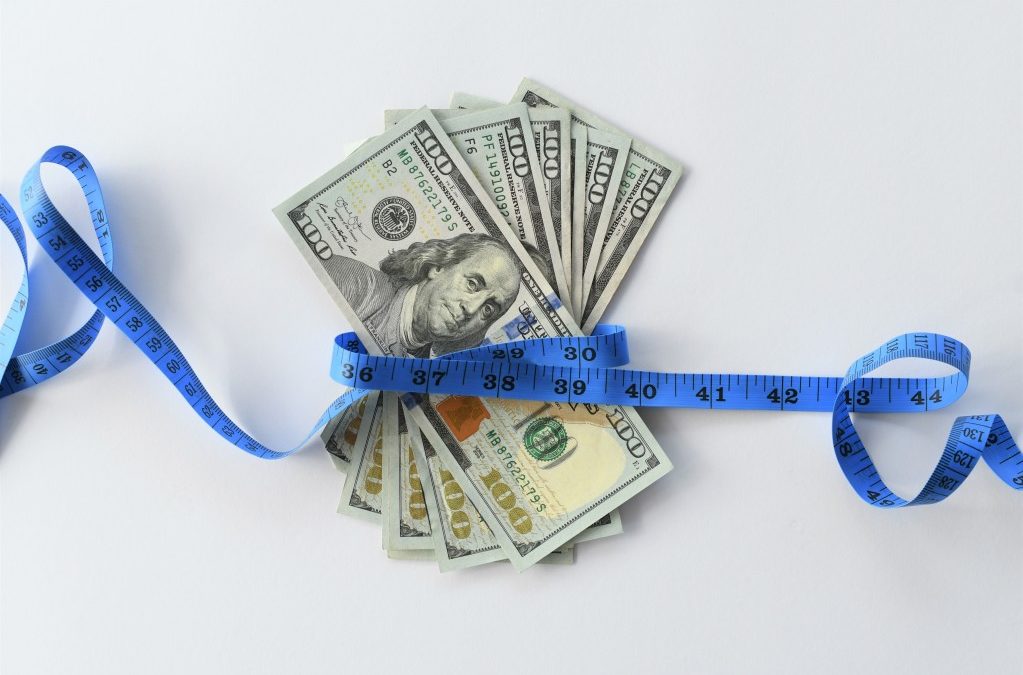 money cash $100 bills hundred dollars wrapped with tape measure cost of losing weight diet eating healthy gym membership